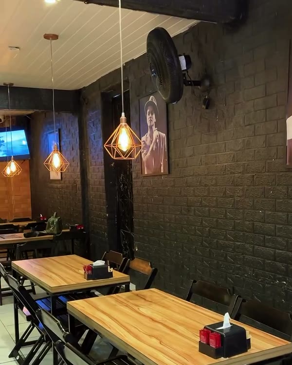Salão da Take Burger com mesas de madeira